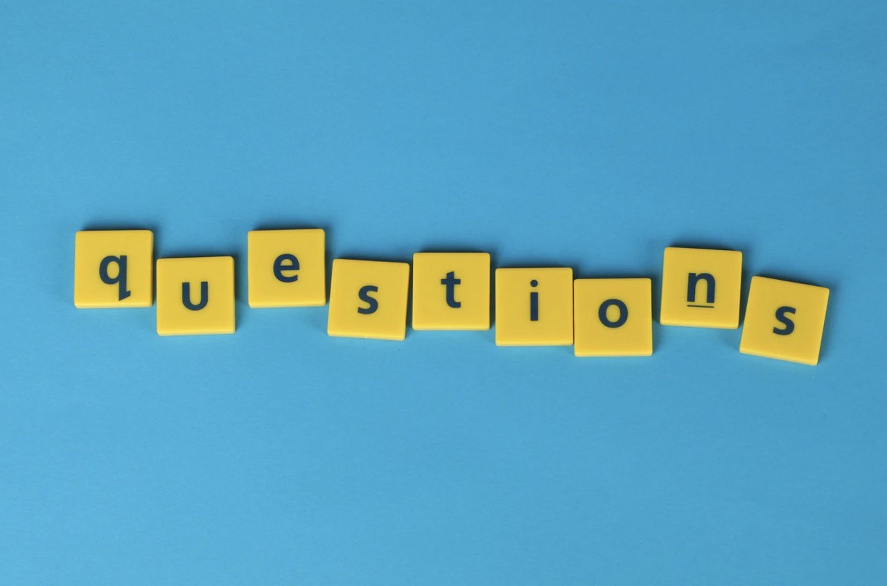 Yellow pieces of wordplay game next to each other creating the word "question" with a blue background