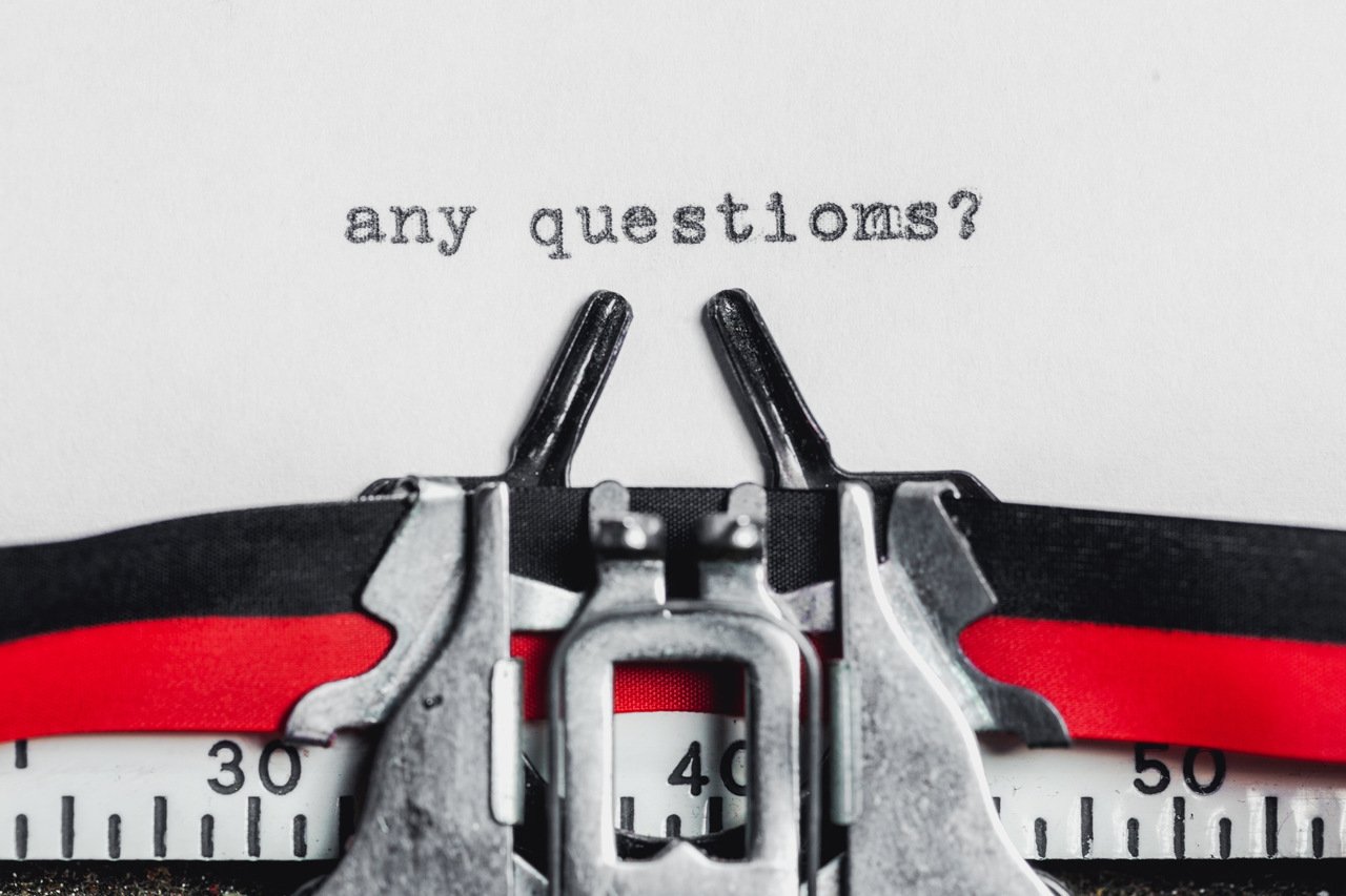 "any questions" written on a typewriter machine
