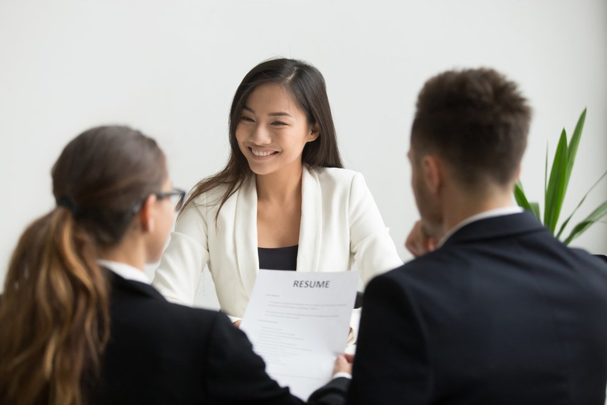 Two human resource people interviewing with a job candidate girl smiling