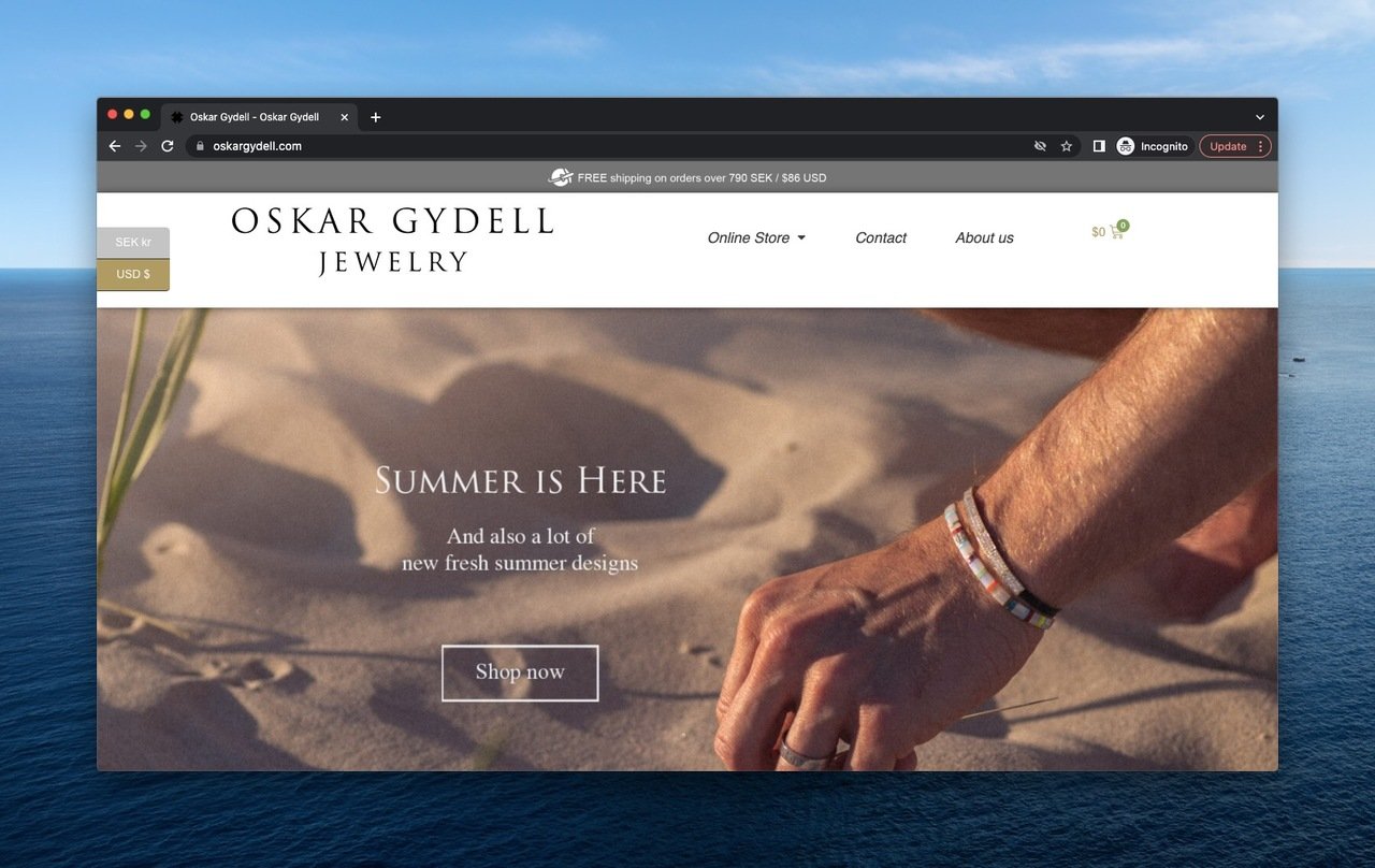Oskar Gydell above the fold example with a hand wearing bracelets touching the sand