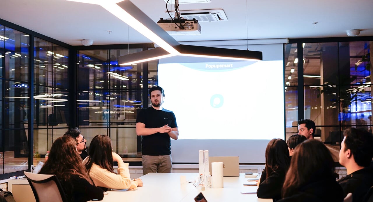 Toplantıda bir masa etrafında oturan Popupsmart ekibi
