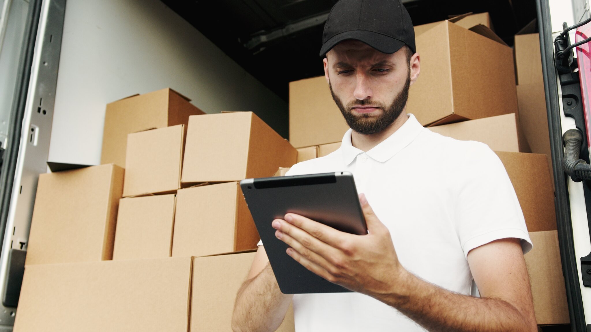 tablet bilgisayar kullanan beyaz polo tişörtlü bir adam