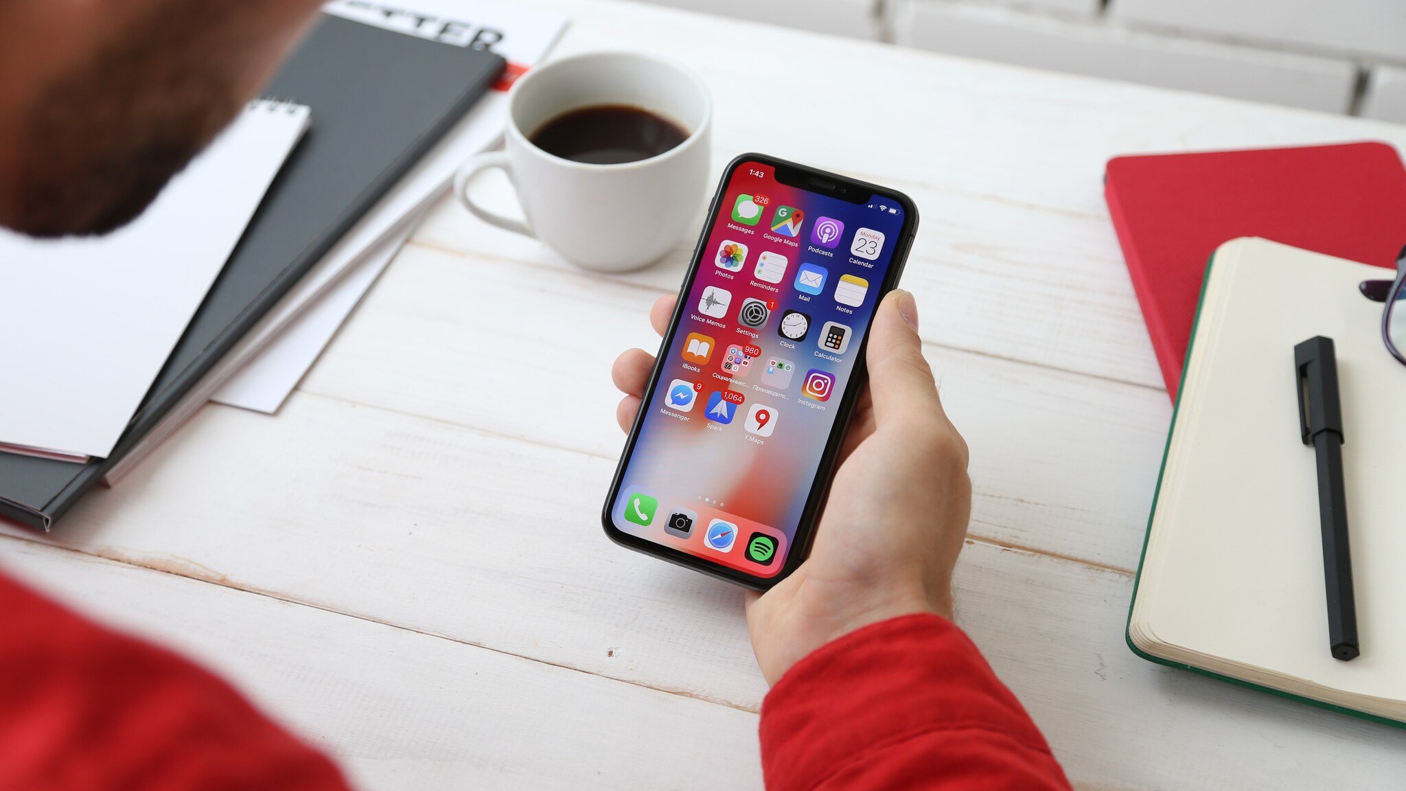mobile push notification strategy shown on an iPhone screen held in hand with coffee in the background