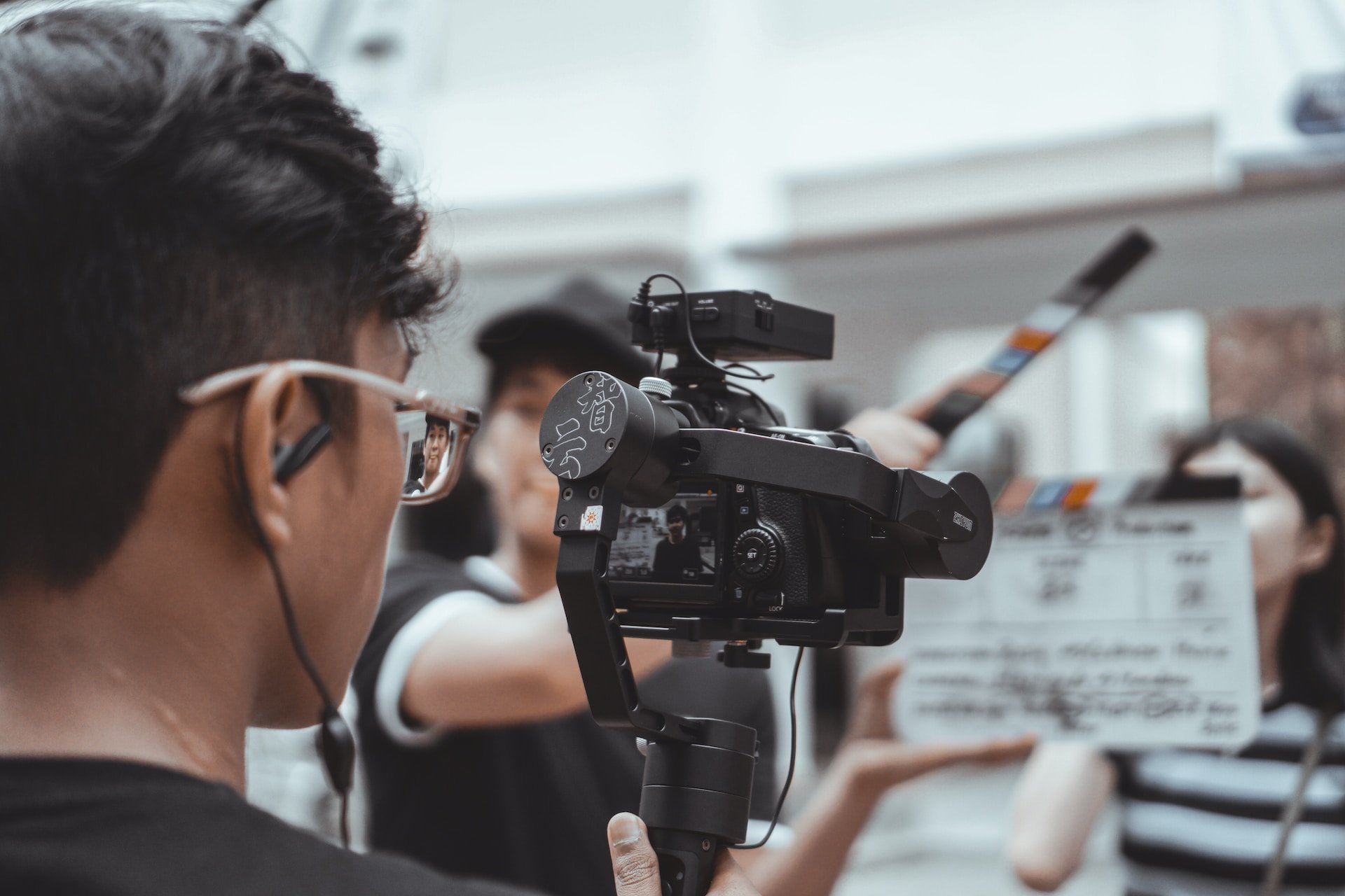 mobile video marketing production as a man in glasses holds a camera and shoots a video