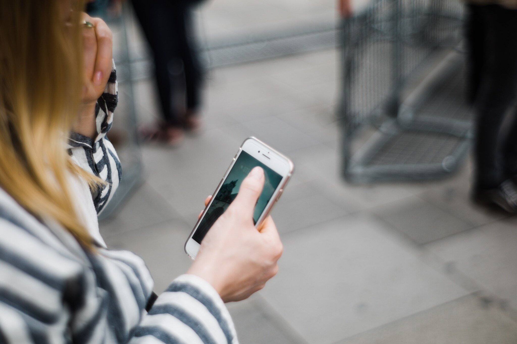 mobile marketing strategy in action as a woman checks her phone in a blurry background