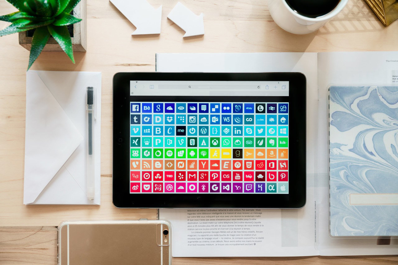 Social media app icons arranged by color on a tablet screen