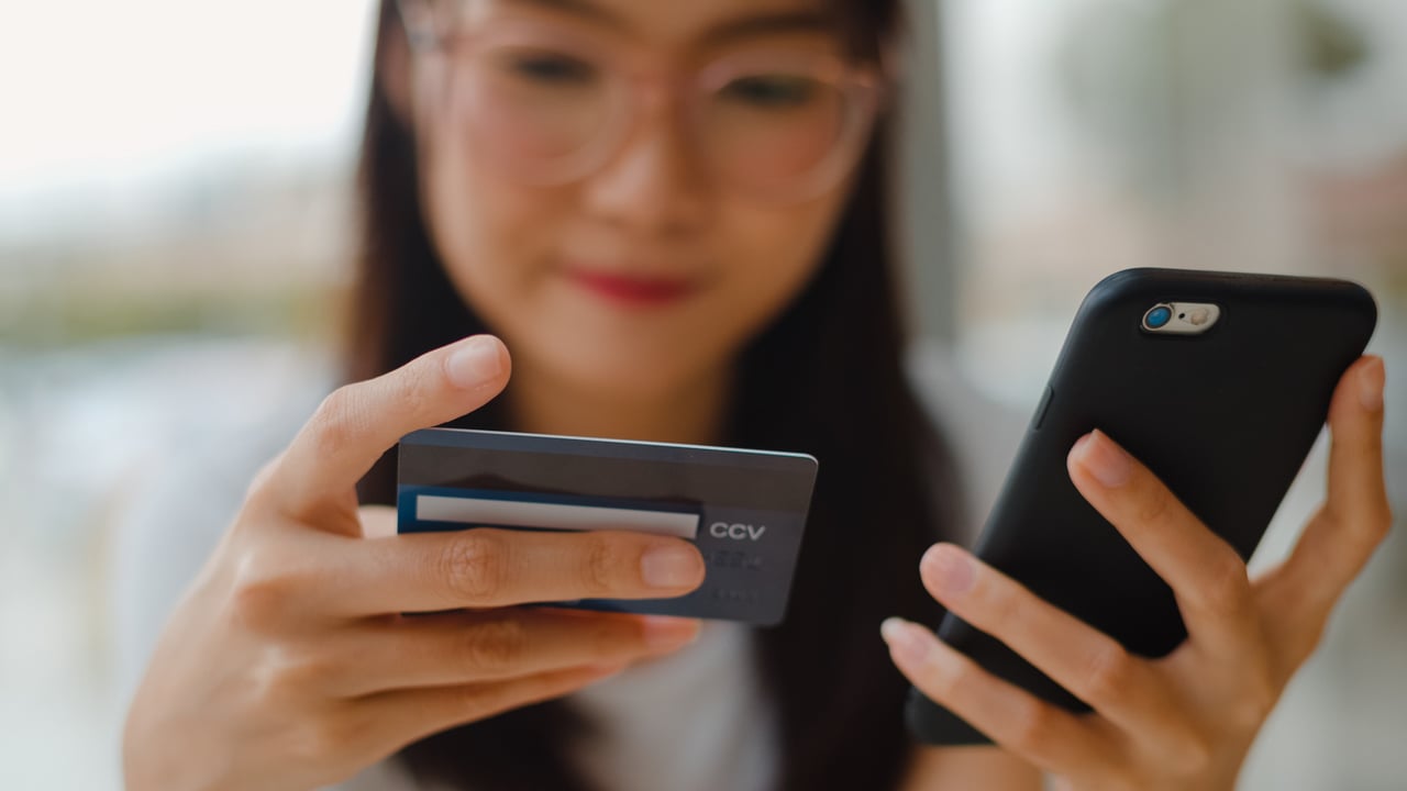 Shopper entering card details on mobile phone with trust indicators visible on screen