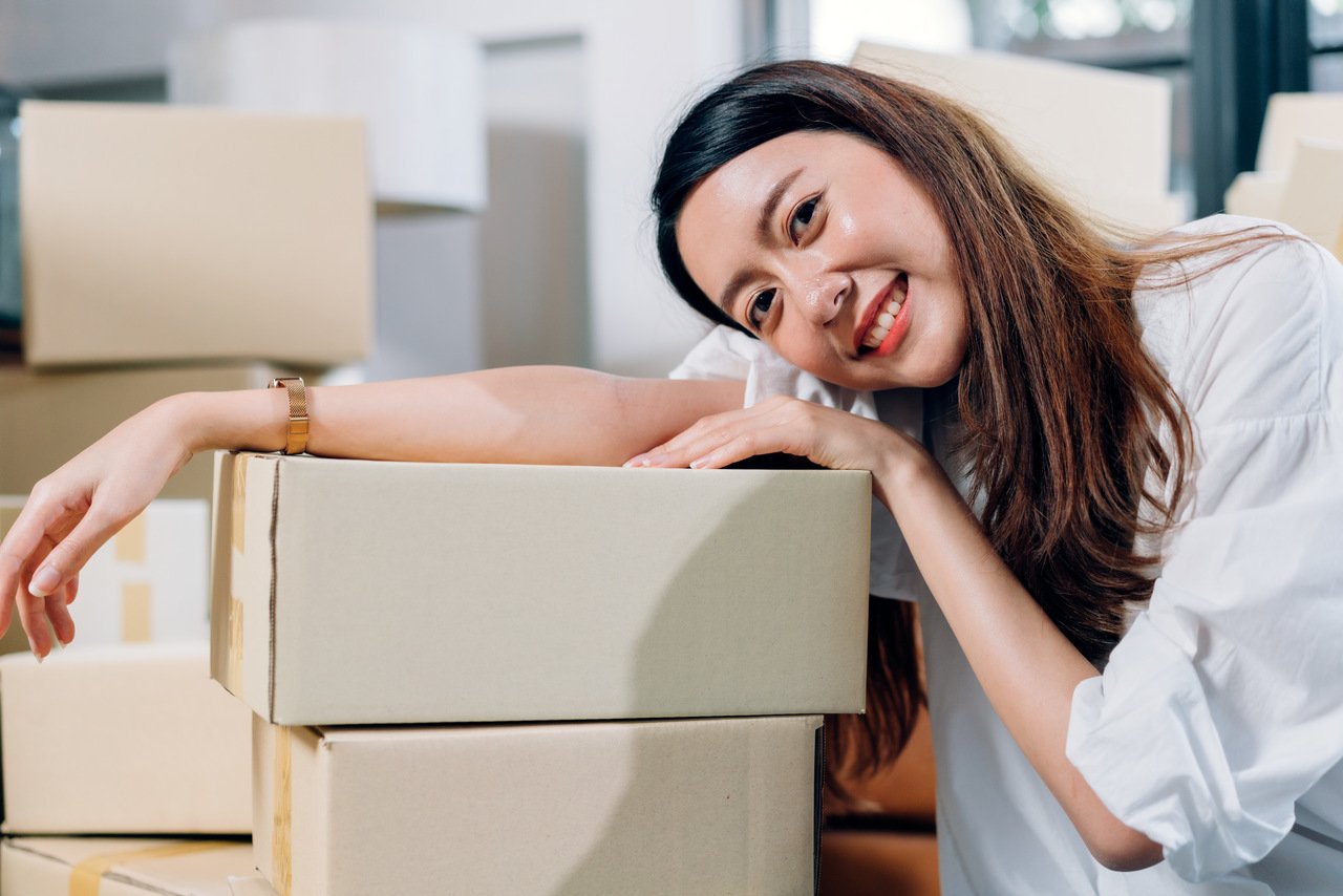 Smiling woman holding a phone, representing authentic user photography that builds trust on mobile sites