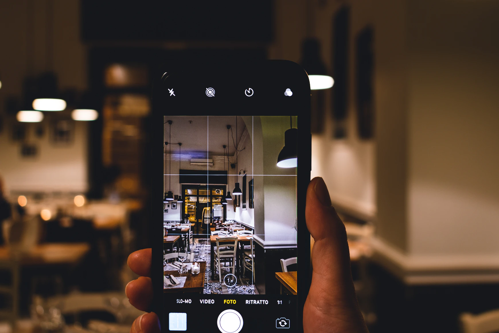 person holding phone in a cafe shooting mobile content for a DTC brand