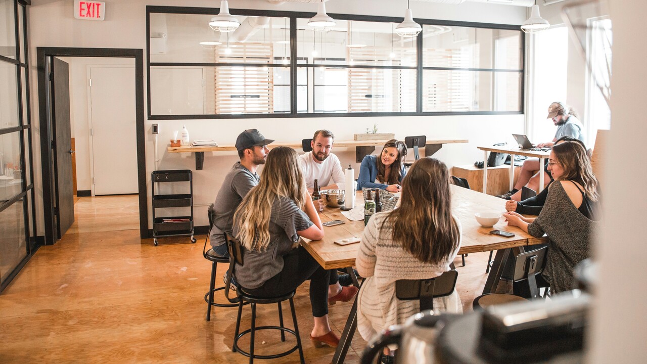 team in an office discussing email marketing strategy and thank-you follow-up messaging