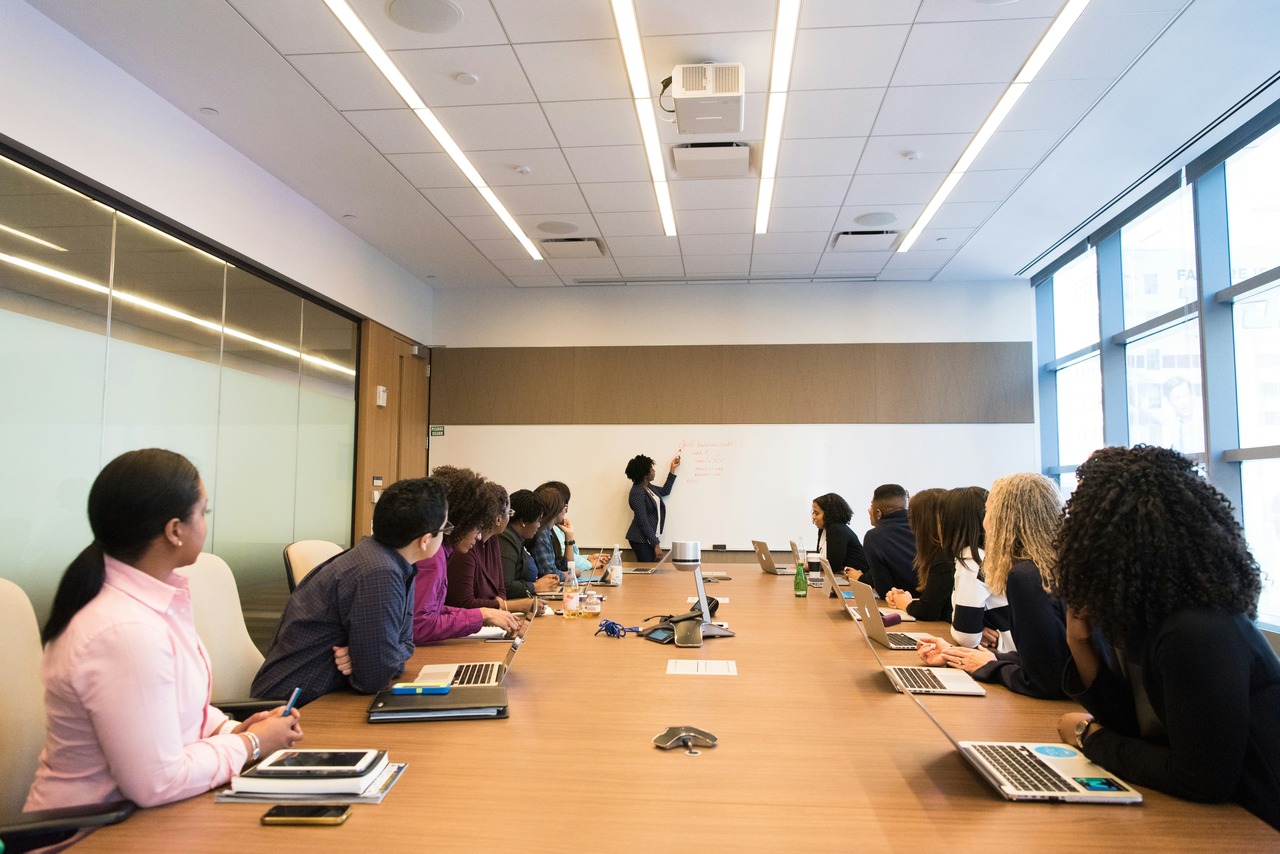 team listening to a presentation that a meeting follow-up email subject line will recap