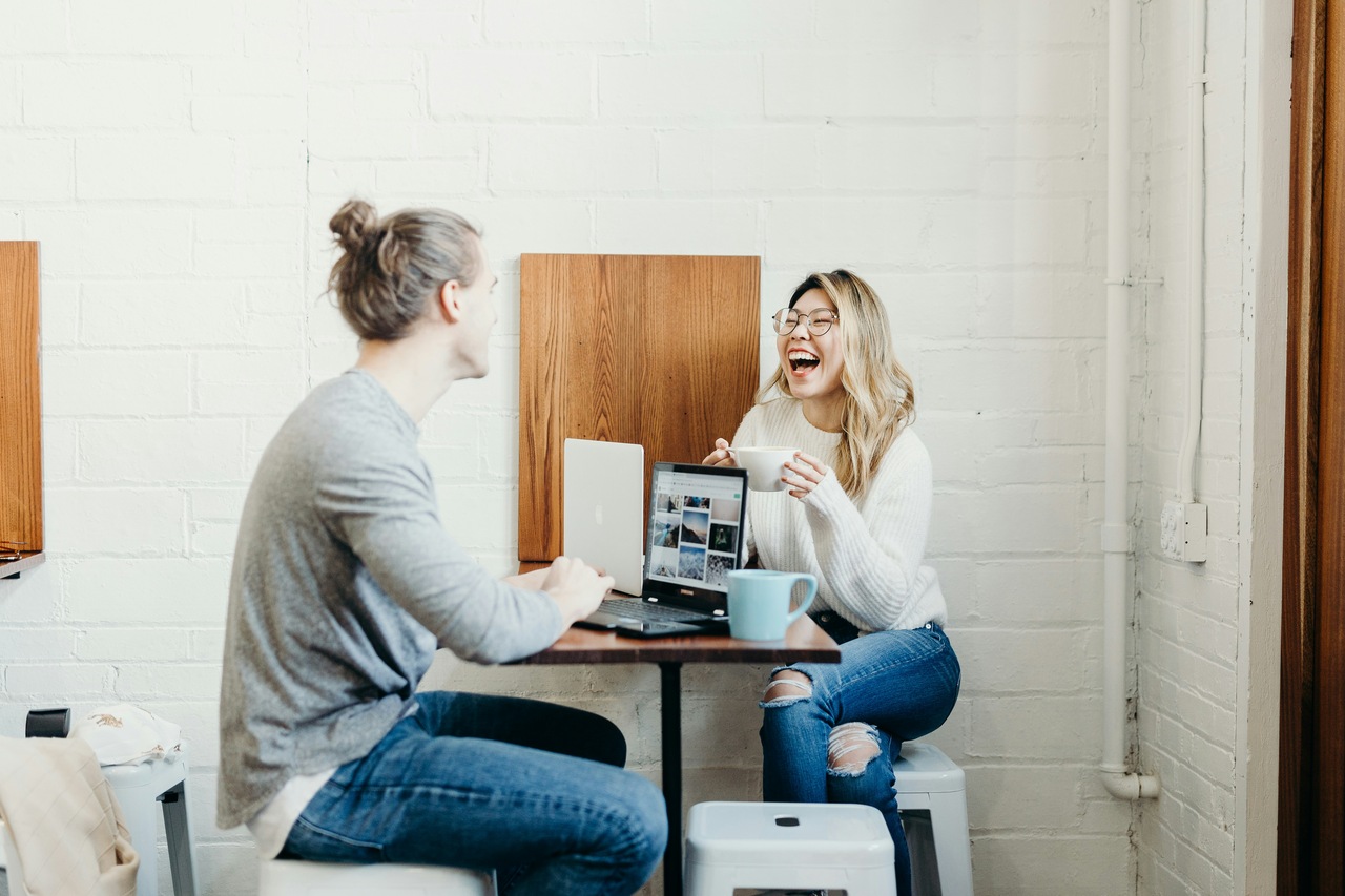 two colleagues having a relaxed conversation while writing a conversational follow-up subject line