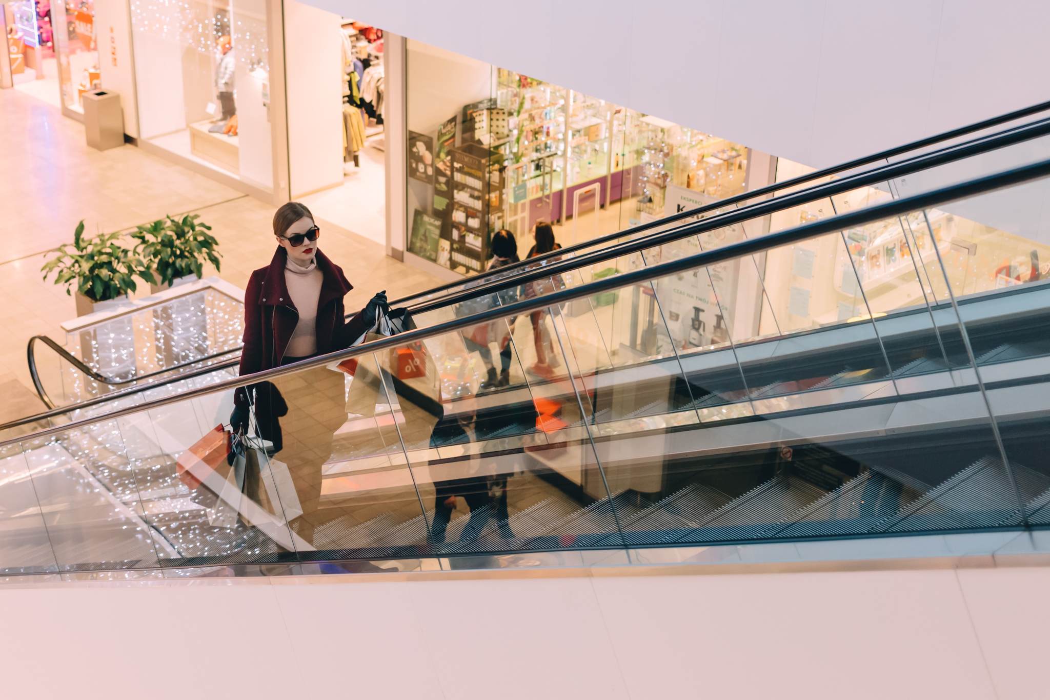 Woman in a shopping mall carrying bags during the holiday season