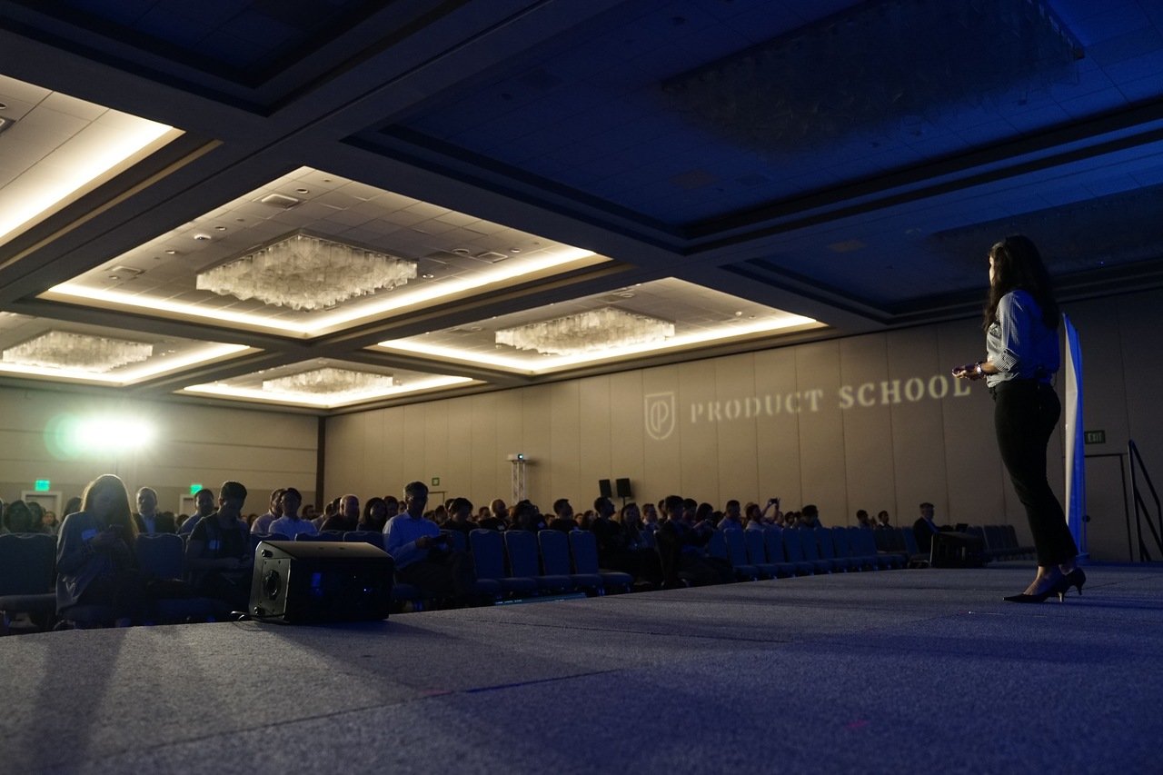 Speaker presenting clear value proposition at a conference to illustrate landing page messaging