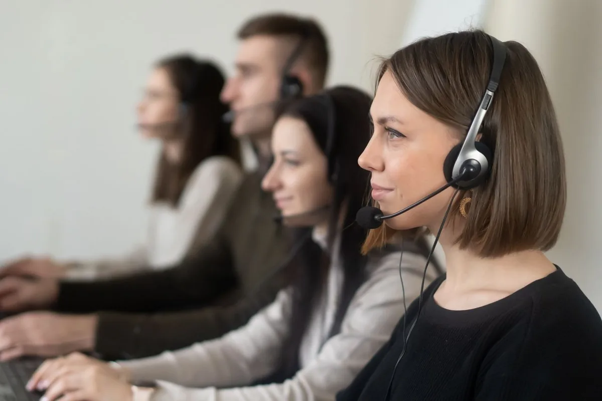 Customer support team wearing headsets at their desks in an office