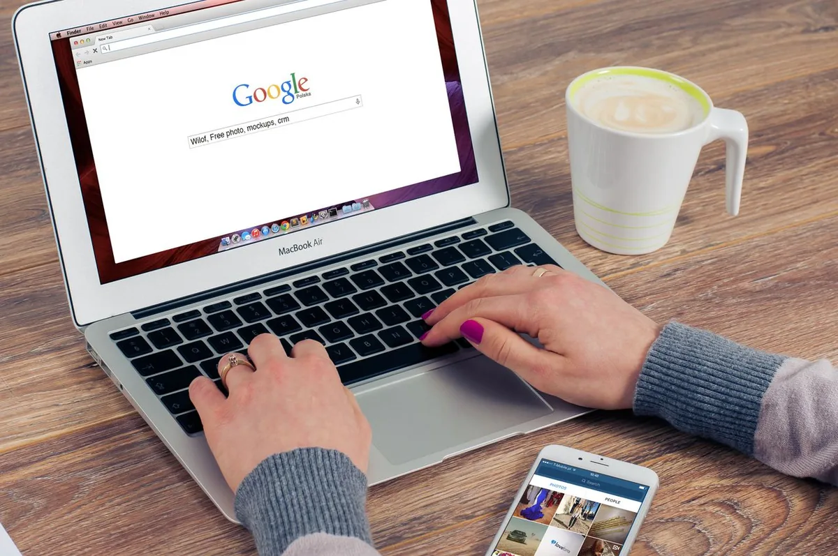 Person using a laptop with the Google search page open for SEO